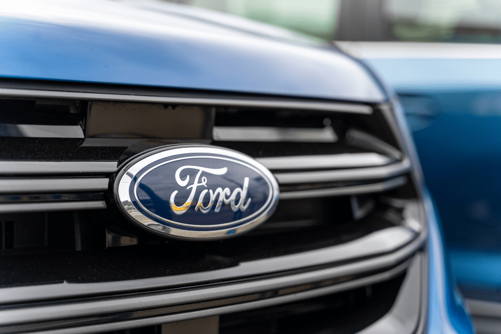 ford maintenance schedule, auto repair in Tea, SD at Sioux Empire Automotive Service Center. Close-up of the iconic Ford logo on the grille of a blue Ford vehicle.