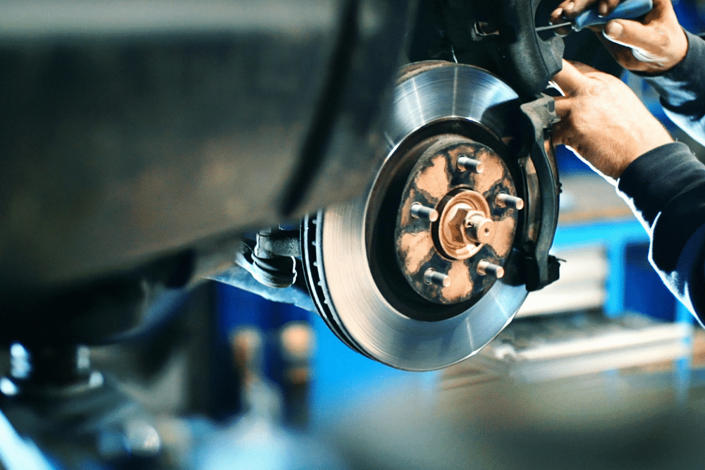 brake repair, auto repair in Tea, SD at Sioux Empire Automotive Service Center. Brake repair in progress. Image shows a technician working on a vehicle’s brake rotor and caliper, highlighting the importance of timely brake maintenance to ensure safety and reliable stopping power.