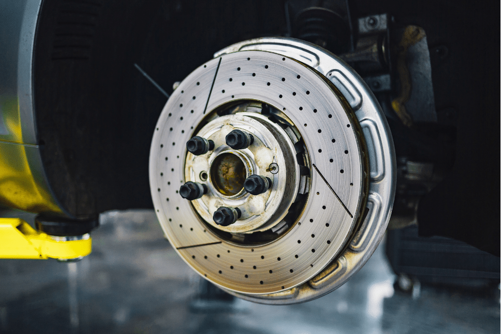 brake repair, auto repair in Tea, SD at Sioux Empire Automotive Service Center. Clean, high-performance drilled brake rotor installed on a vehicle, showcasing precision brake components ready for high-performance driving.