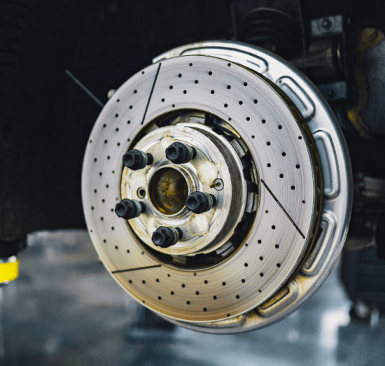 brake repair, auto repair in Tea, SD at Sioux Empire Automotive Service Center. Clean, high-performance drilled brake rotor installed on a vehicle, showcasing precision brake components ready for high-performance driving.