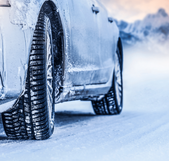 Tire service in Tea, SD by Sioux Empire Automotive Service Center. Close-up of winter tire tread gripping snowy road, highlighting traction and safety for South Dakota driving.